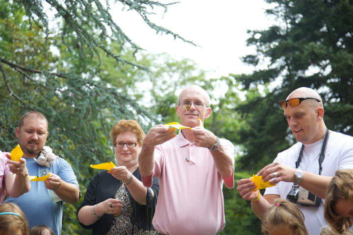 A group of adults releasing butterflies at memorial event