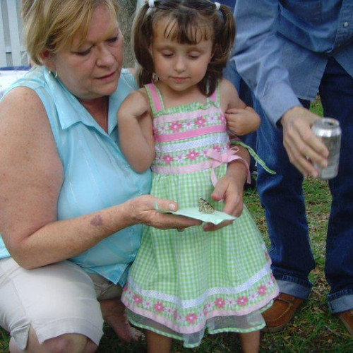 A young girl and a woman releasing a butterfly at a memorial event
